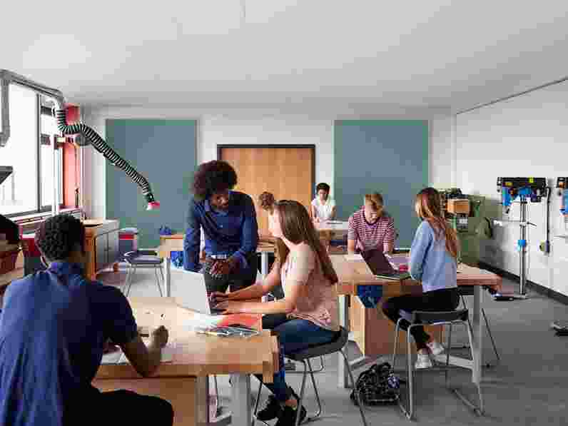 Profesor y alumnos en un aula con absorbentes de pared