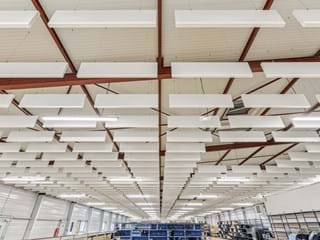 Photo en vue plongeante de nombreuses baffles acoustiques suspendues au plafond organisées en plusieurs rangées.