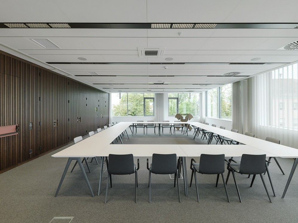 salle de réunion avec grande table et panneaux acoustiques au plafond