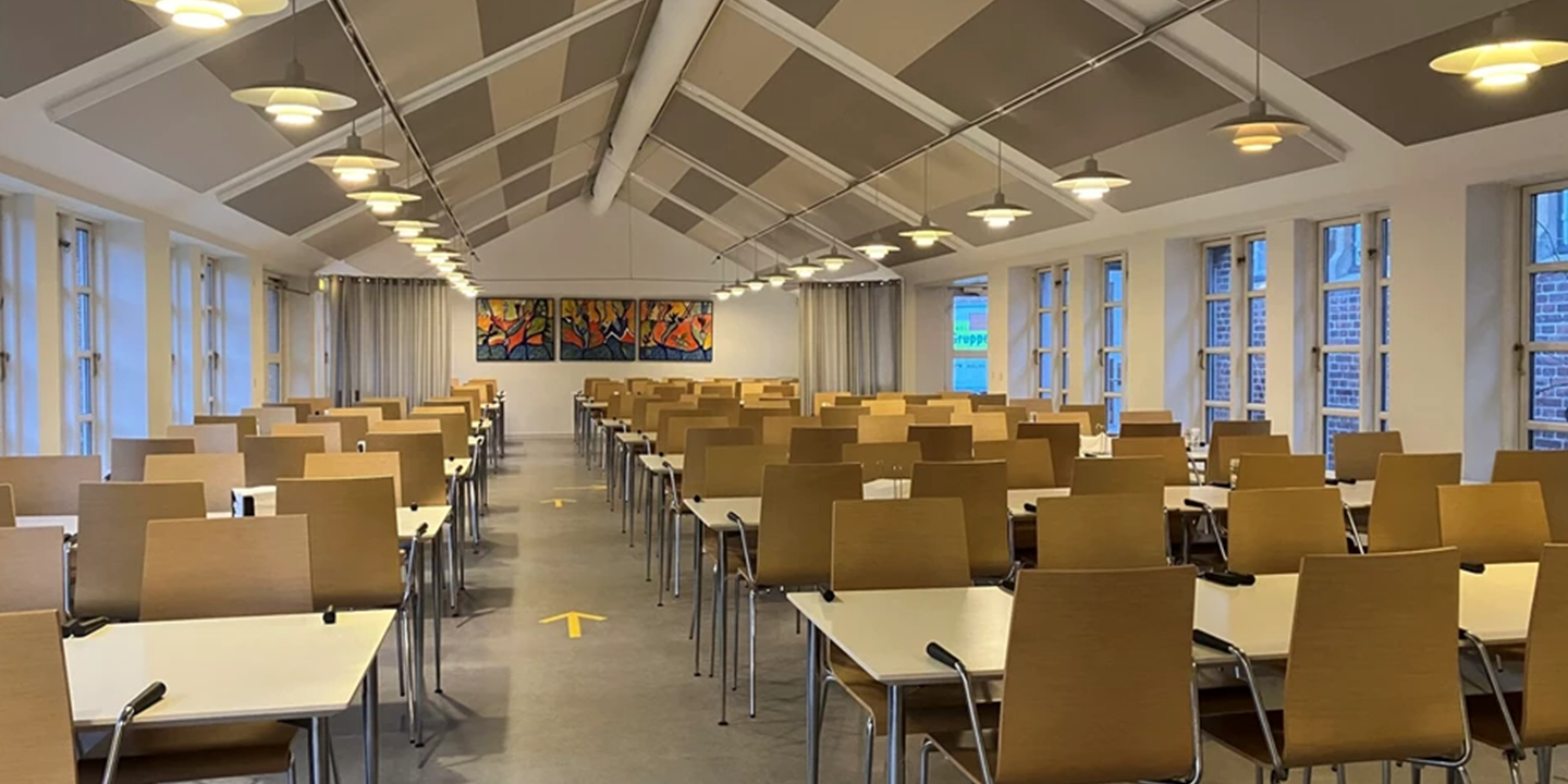 Salle de cafétaria avec chaises et tables et panneaux acoustiques au plafond