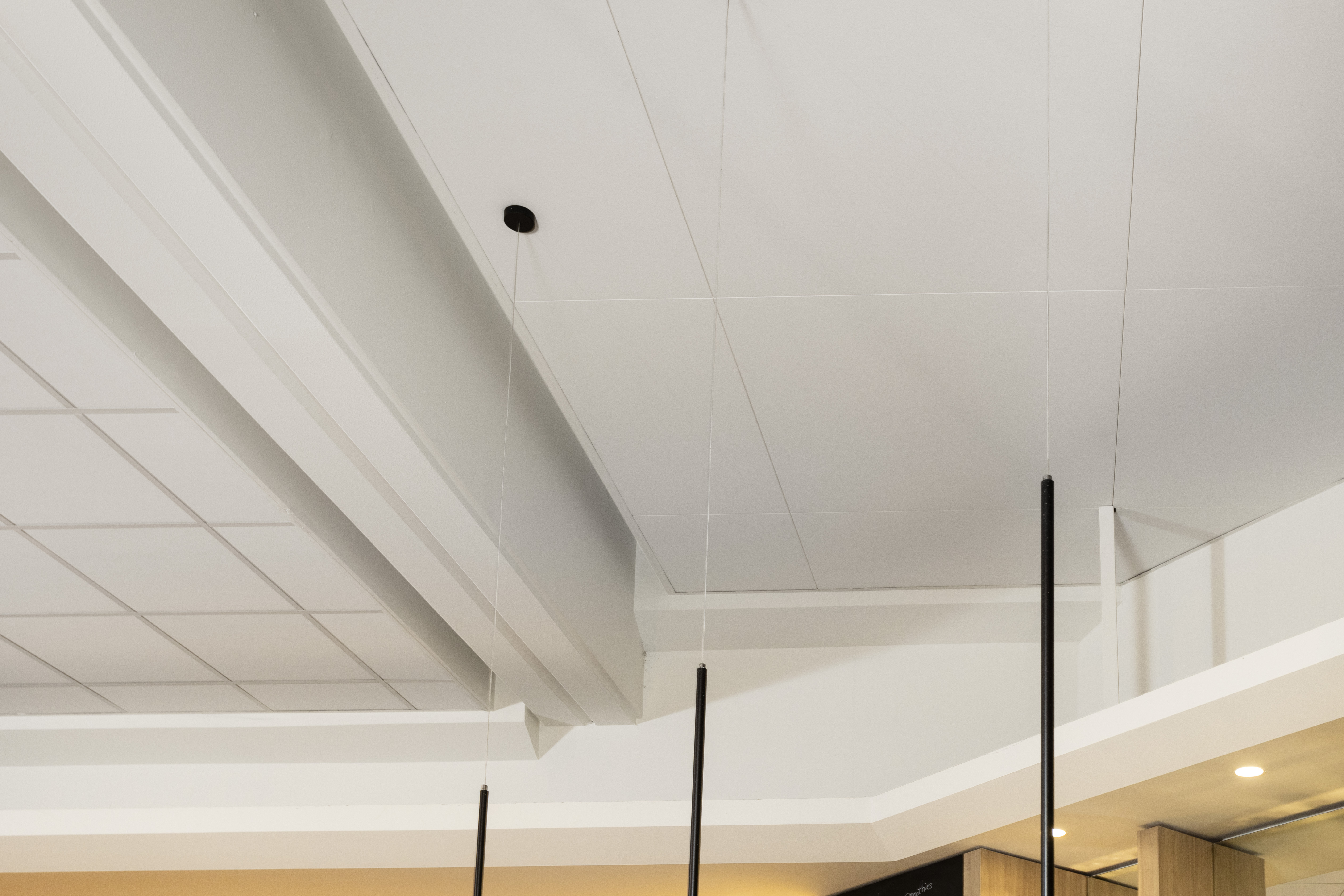 Photo de près du plafond à deux niveaux avec les dalles acoustiques