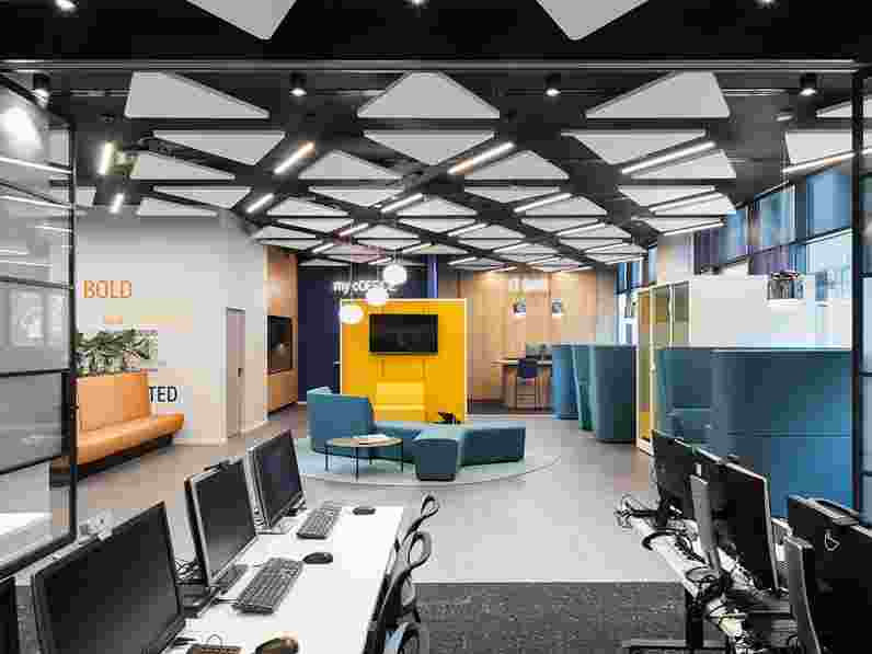 Triangle shaped free-hanging acoustic panels  in open-plan office with colourful furniture