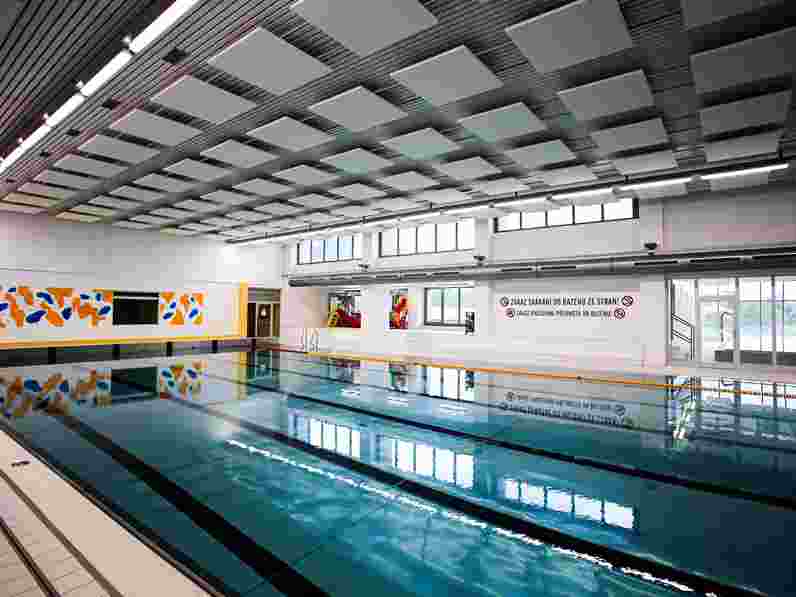 Free-hanging acoustic ceiling panels in swimming pool