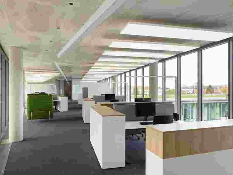 Open-plan office with concrete ceiling and free-hanging acoustic panels