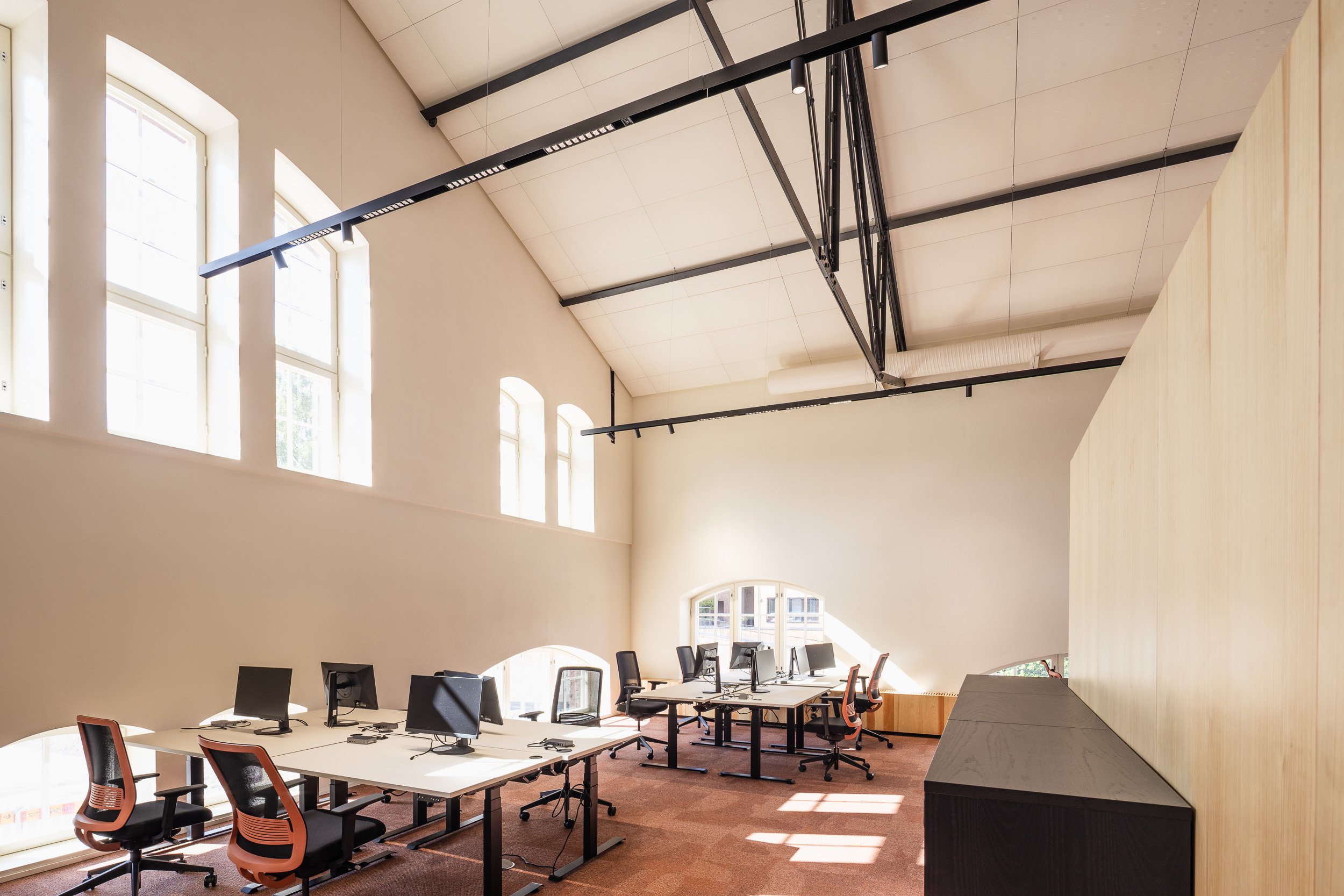 Moderniksi työympäristöksi muutettua tilaa, jossa on valkoinen akustiikkakatto