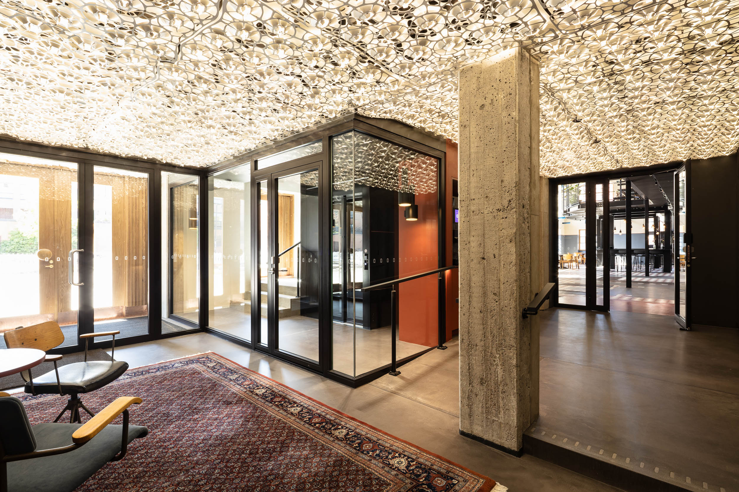 Kuvassa valokatto: aulaan suunniteltiin yhteistyössä valaisinmuotoilija Petri Vainion kanssa monikerroksinen, läpäisevä metallivalokatto.