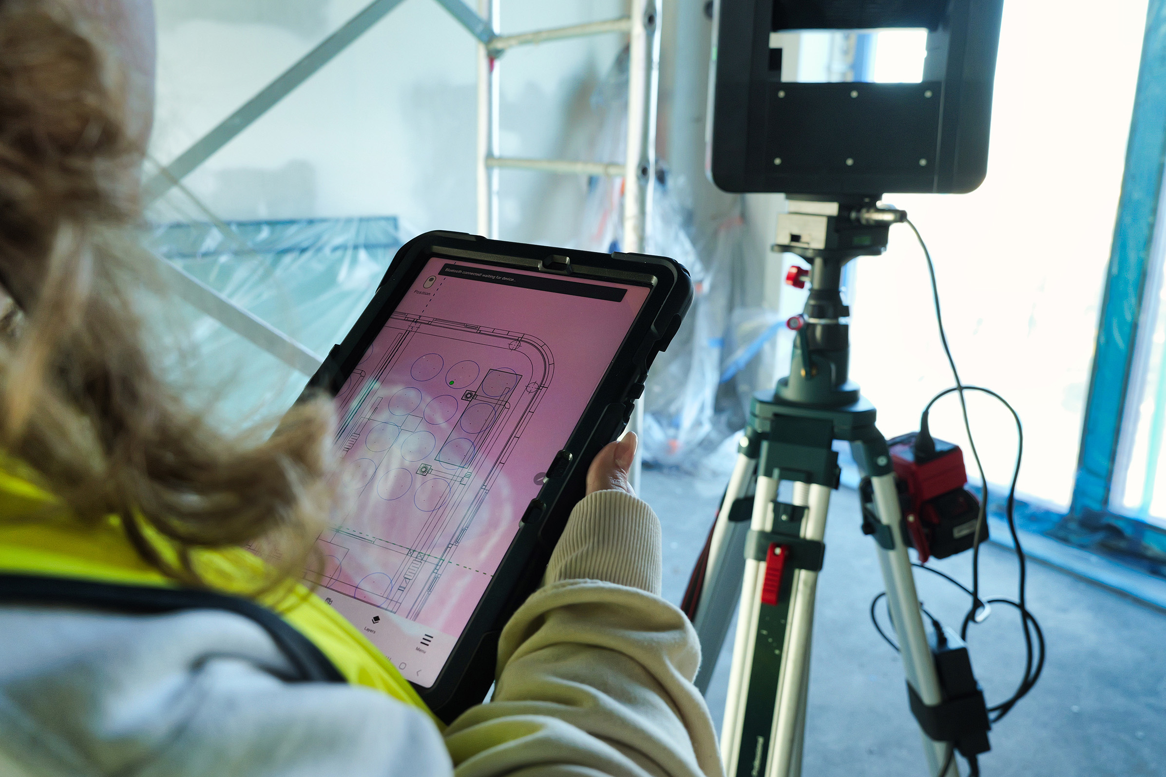 Tablet displaying digital layout connected to laser projection equipment used for precise on-site installation