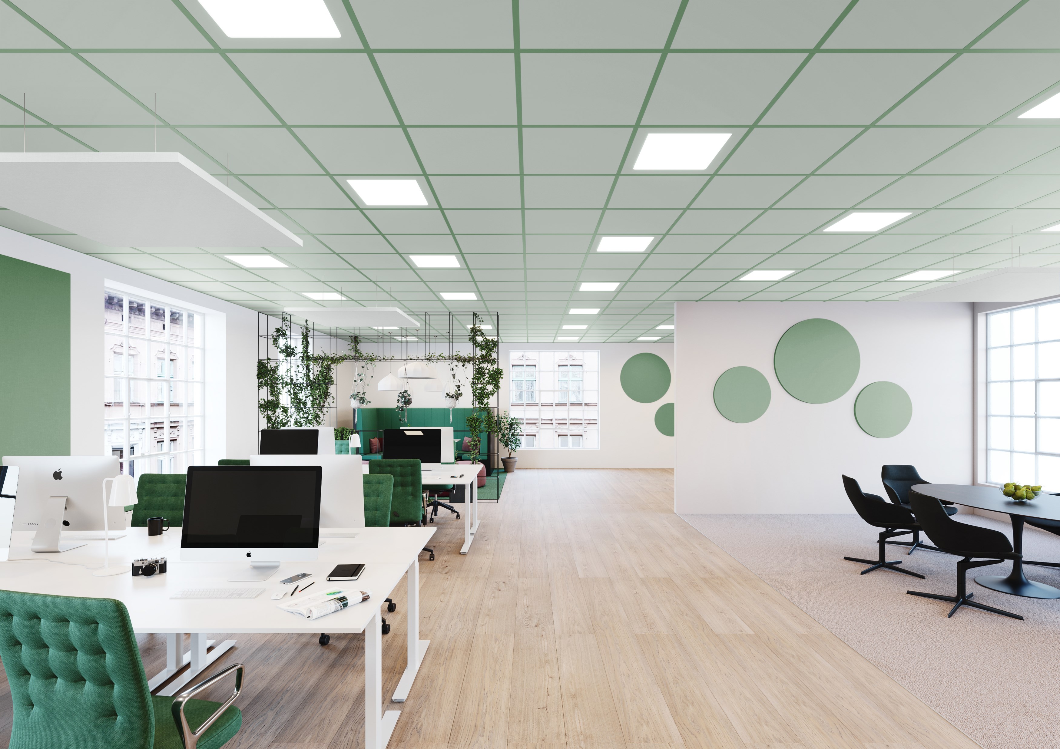 A modern, spacious office with white desks and green chairs. The room features a wooden floor, green and white walls with circular decorations, and large windows allowing natural light. Indoor plants add a touch of greenery.