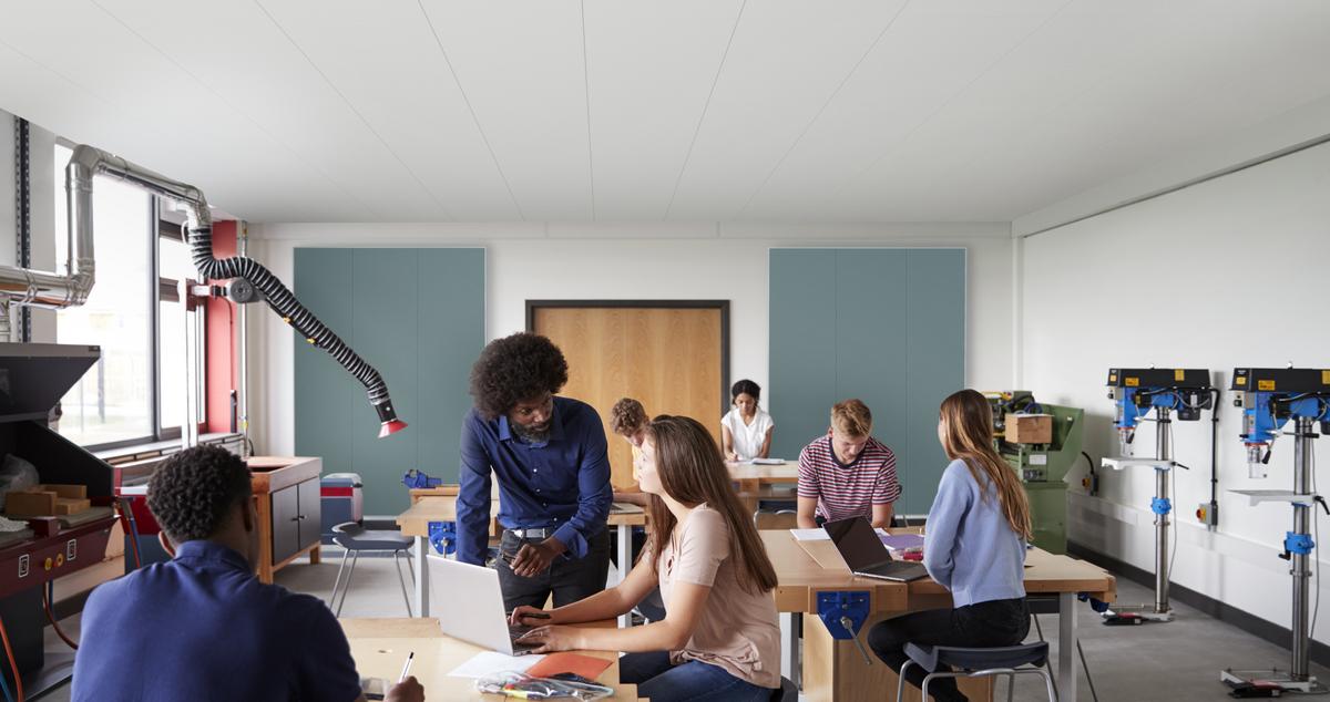 People in classroom with large acoustic wall panels mounted on back wall