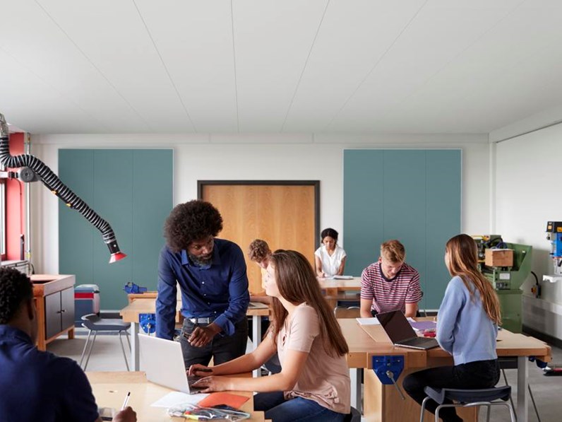 People in classroom with large acoustic wall panels mounted on back wall