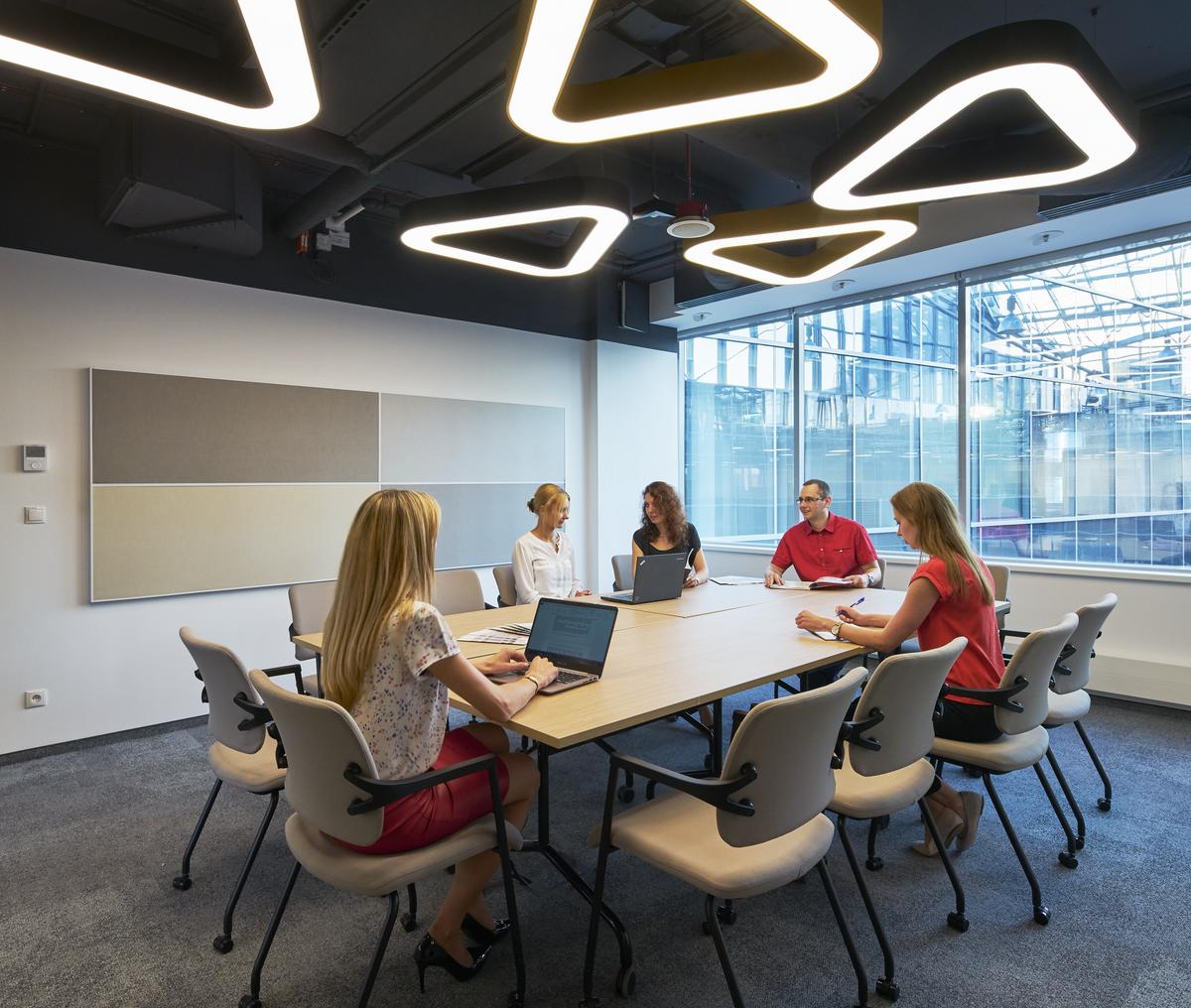 People in meeting room with acoustic wall panels with visible frame