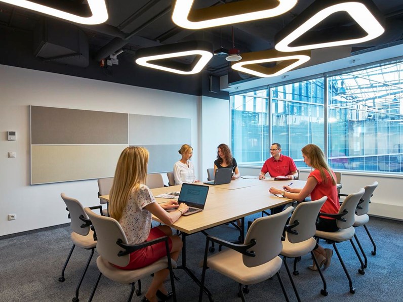 People in meeting room with acoustic wall panels with visible frame