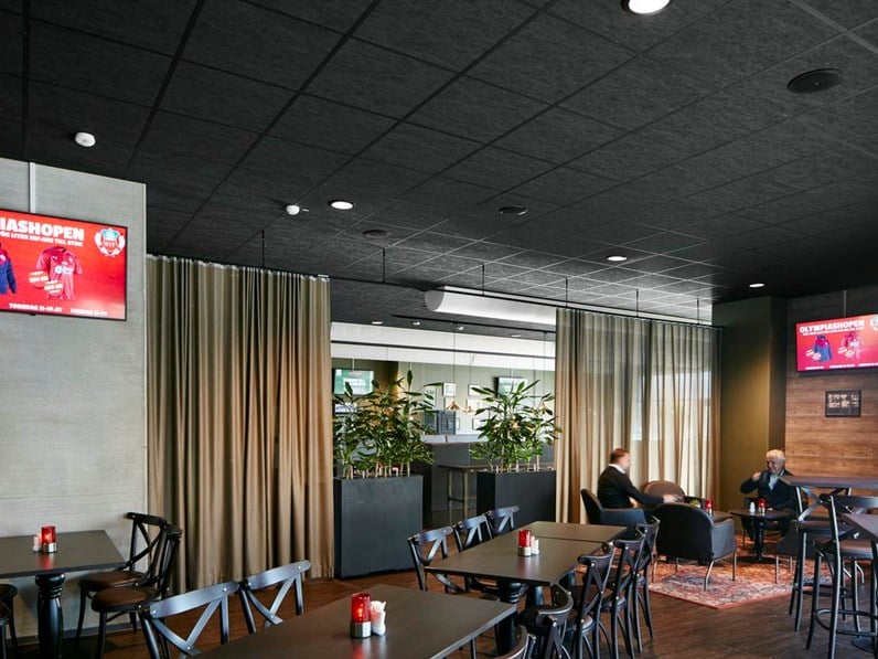 Restaurant at Olympia Arena with matte black acoustic ceiling system Ecophon Sombra™