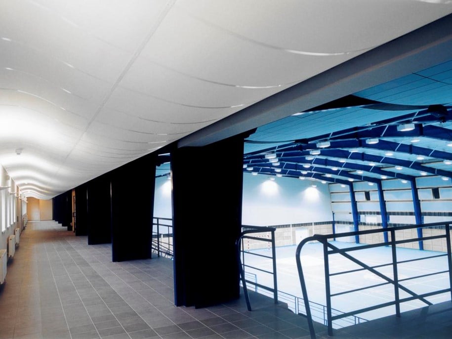 Curved acoustic ceiling tiles, Ecophon Focus™ Flexiform A, installed in sportshall corridor