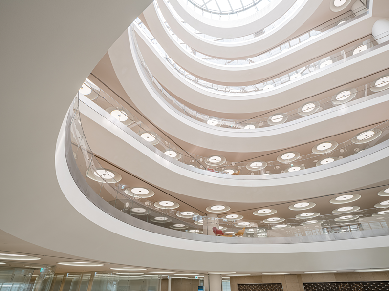 Multi-storey office lobby with acoustic plaster ceiling