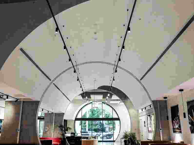 Sala en forma de túnel con techo abovedado revestido de enlucido acústico