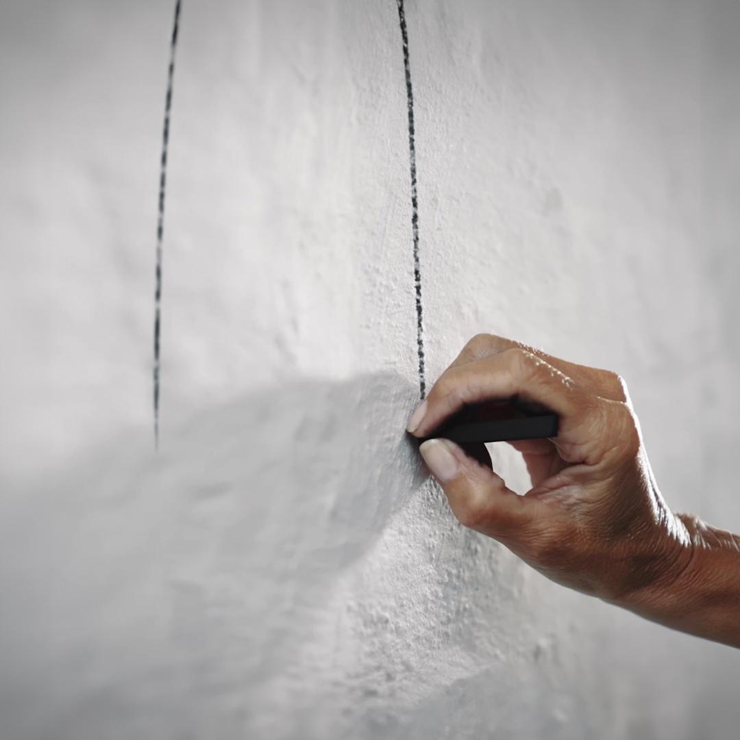 Close-up of hand making a sketch on a wall