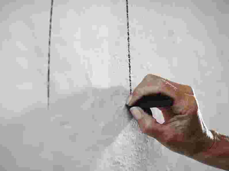 Närbild av en hand som gör en skiss på en vägg